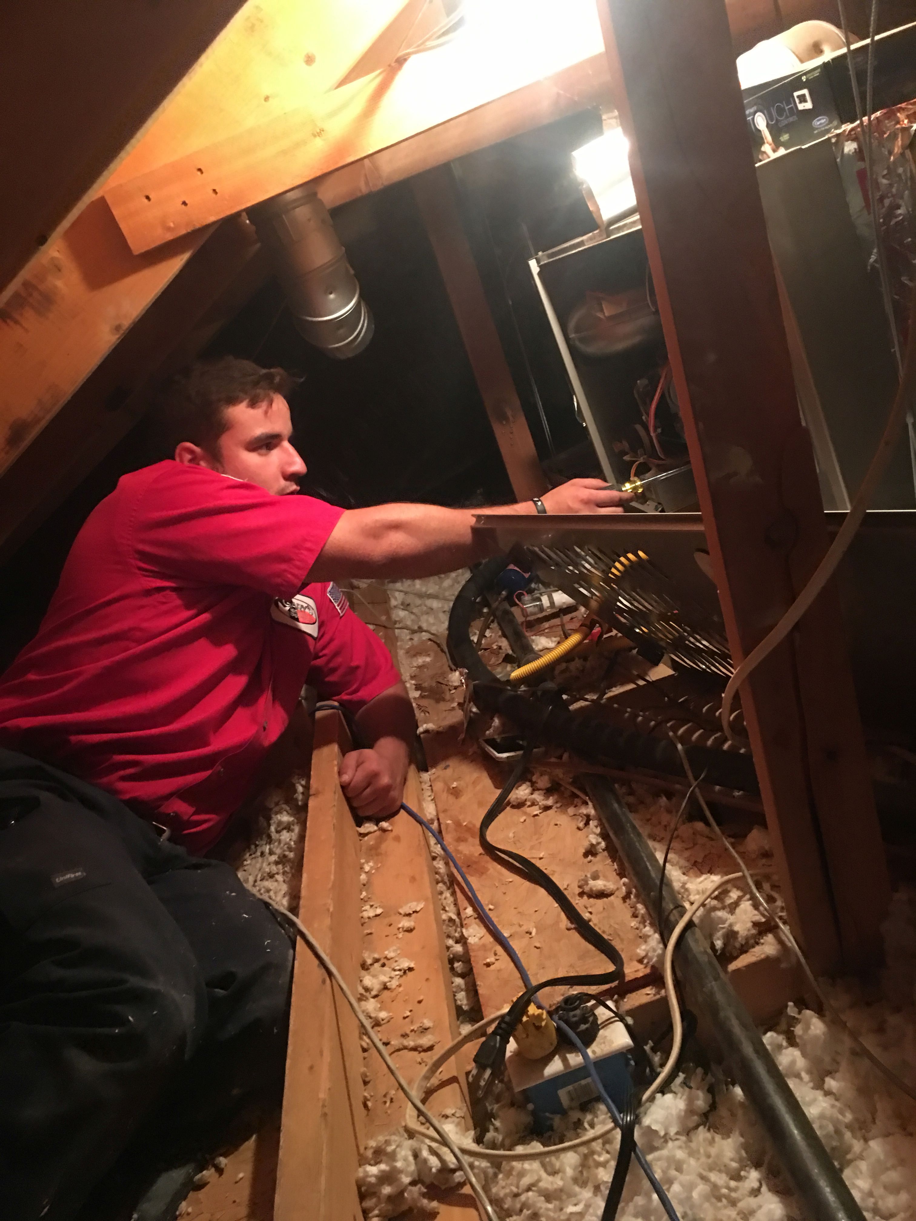 AC Technician Working on AC Repair in Attic